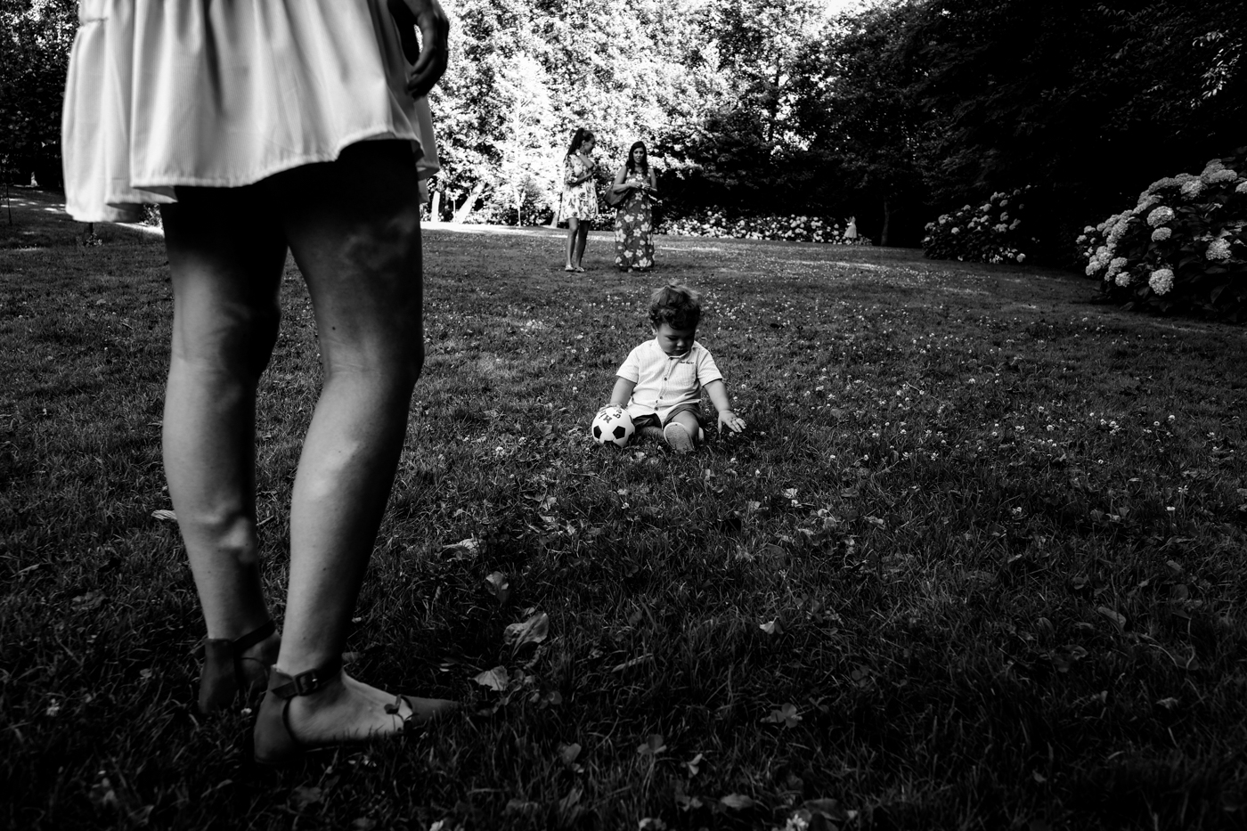 bambino seduto nell'erba del giardino del ristorante matrimonio