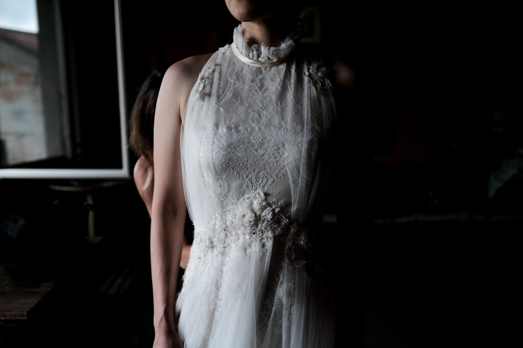 dettaglio del ricamo di un abito da sposa con sarta