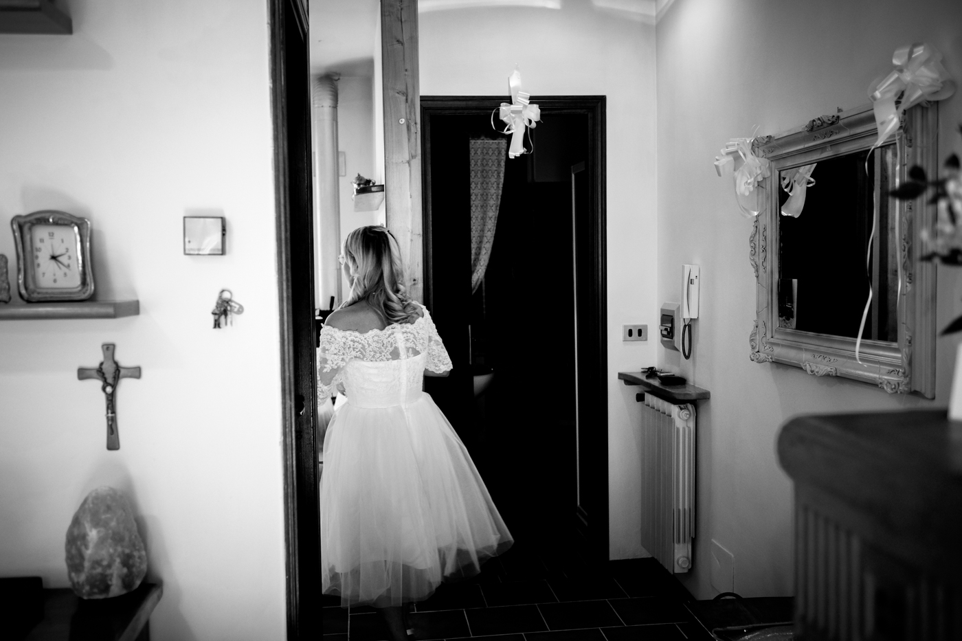 sposa di spalle in casa con crocifisso