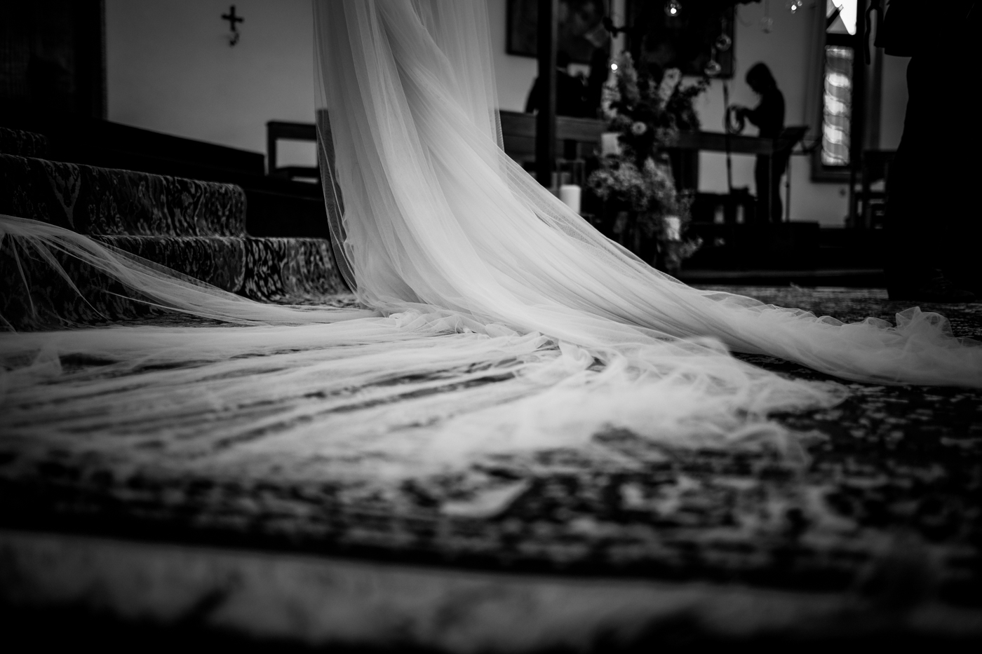 il velo della sposa poggia sul tappeto in chiesa