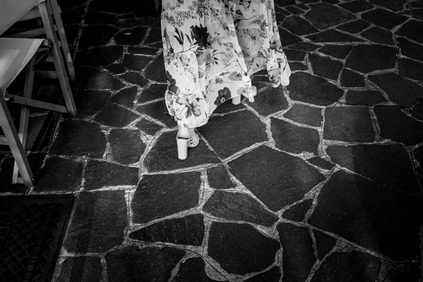 piedi con zeppe di un'invitata su pavimento di pietra