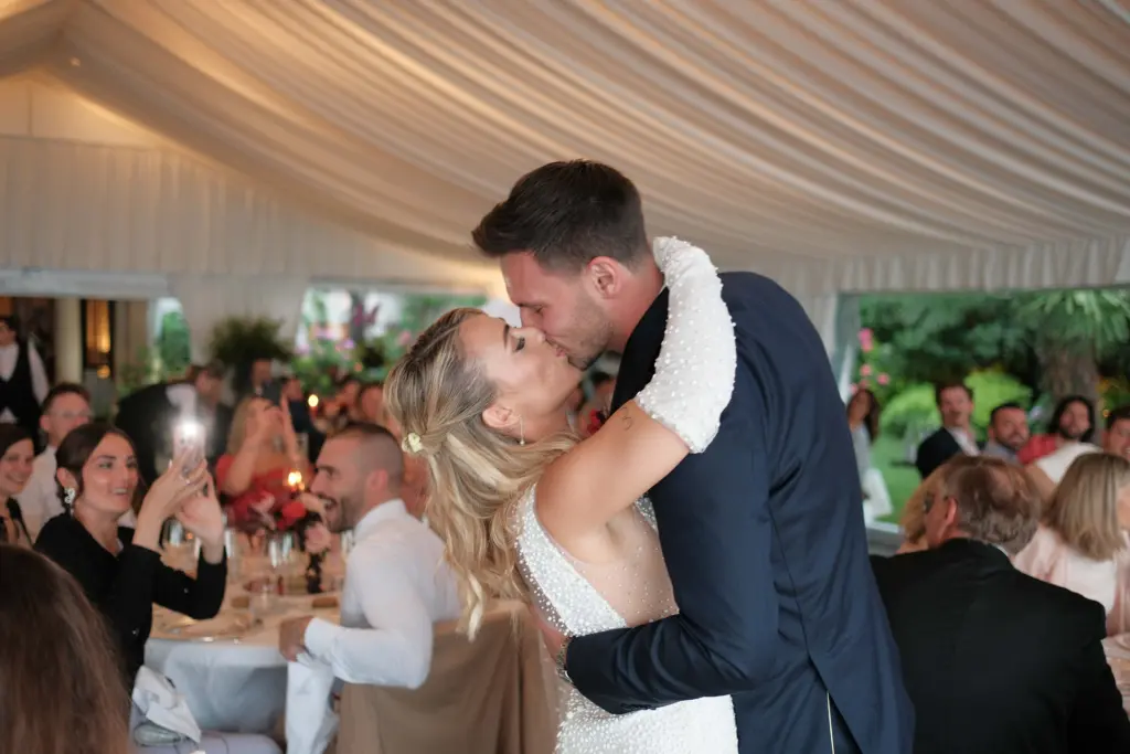 Matrimonio a Villa Fiordaliso, Lago di Garda – bacio degli sposi tra gli invitati a cena